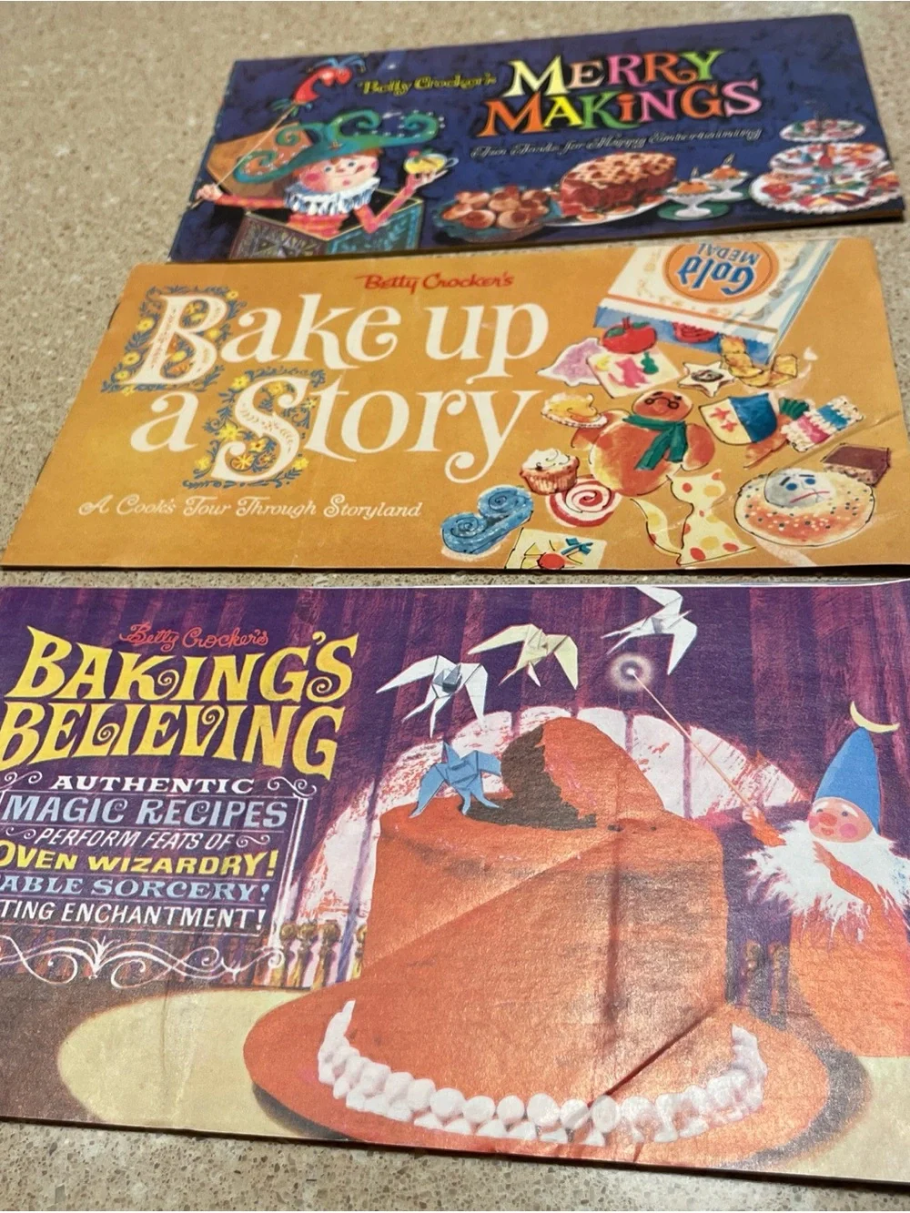 Betty Crocker cookbook set with purple, orange, and yellow covers